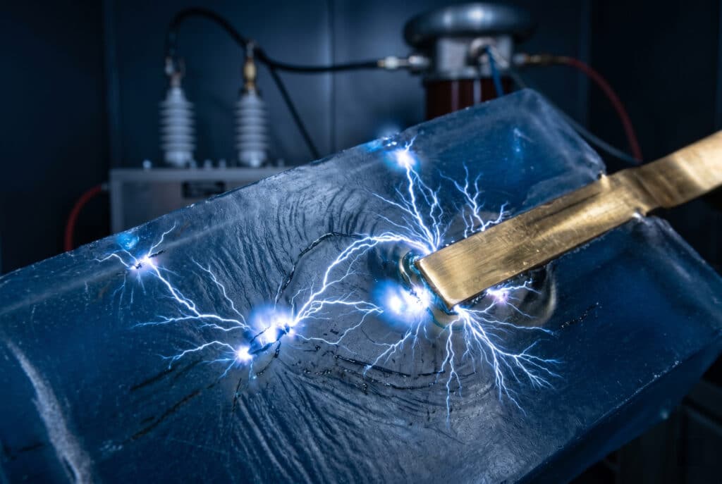 Une décharge électrique localisée se produisant activement à la surface et dans de petits vides d'un composant en résine moulée, démontrant les dommages cumulatifs causés par une décharge partielle.